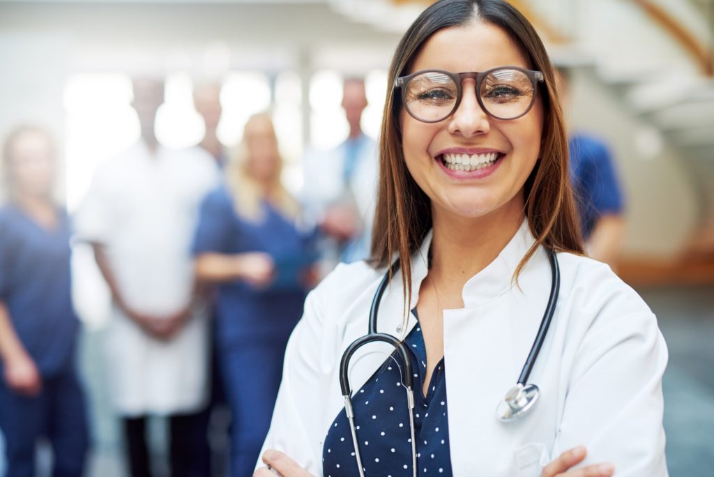 Smiling young doctor wearing glasses in clinic